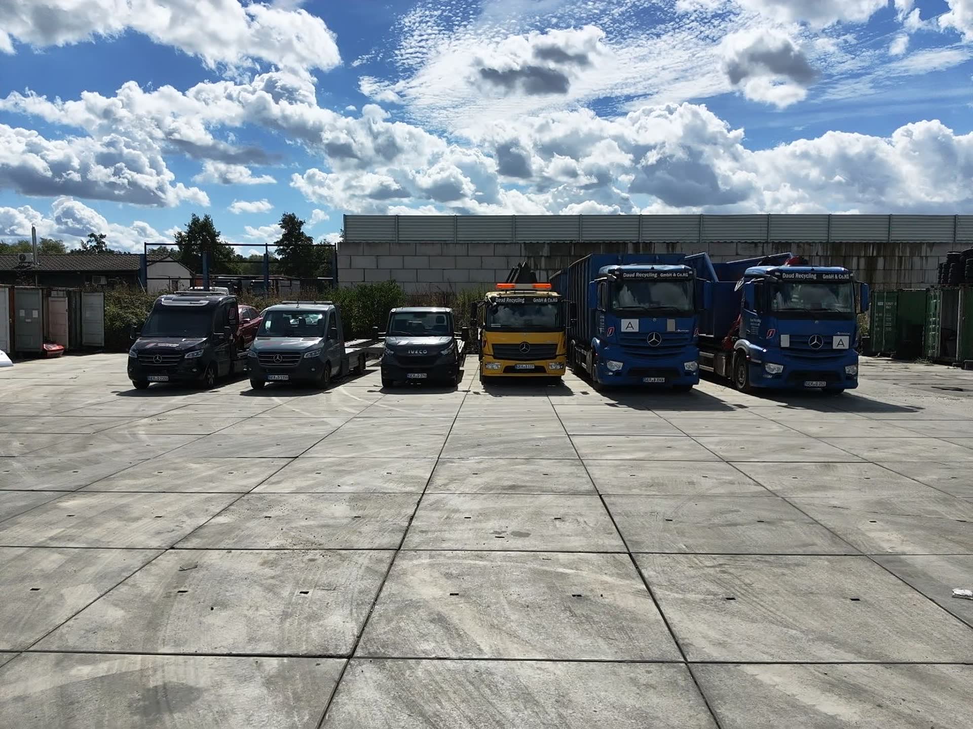 Sprinter mit Anhängern, Abschleppwagen und Lkw von Daud Recycling nebeneinander auf dem Betriebshof